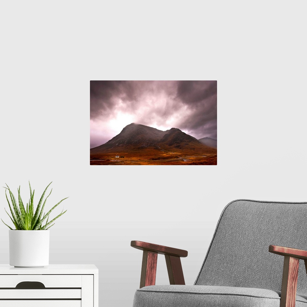 A modern room featuring A majestic Scottish mountain in Glencoe with dramatic storm clouds and rich autumn colours with a...