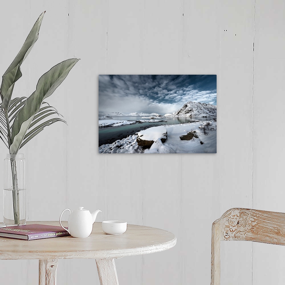 A farmhouse room featuring A photograph of a rugged winter landscape under a sky of dark clouds.