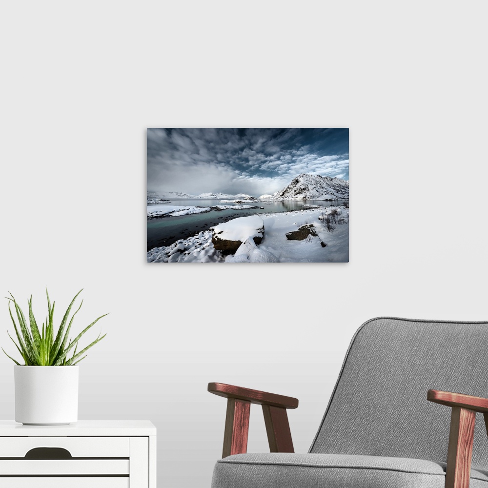 A modern room featuring A photograph of a rugged winter landscape under a sky of dark clouds.