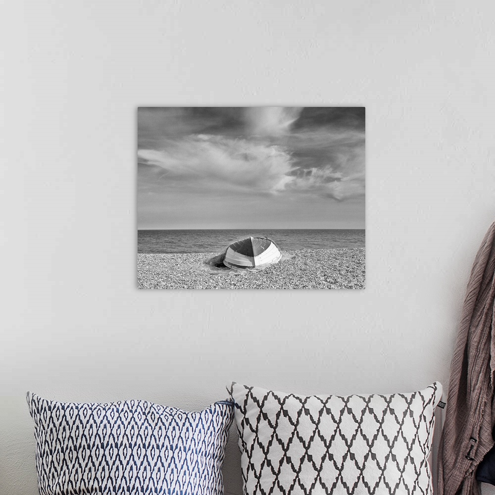 A bohemian room featuring A monochrome black and white image of an upturned rowing boat on an English shingle beach in brig...