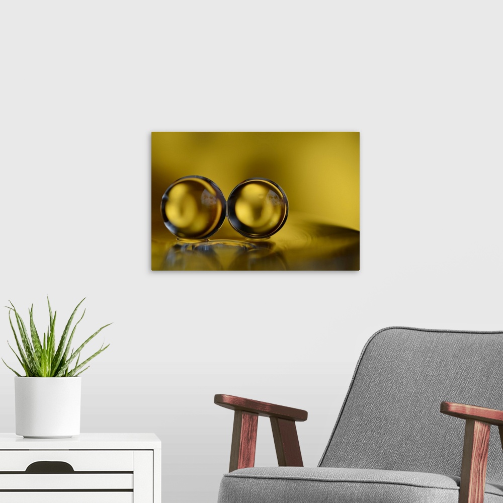 A modern room featuring Macro photograph of two water drops side by side and reflecting onto the yellow surface below them.