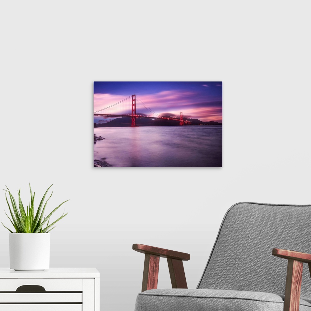 A modern room featuring Landscape photograph of a purple and pink sunset over the Golden Gate Bridge in San Francisco wit...