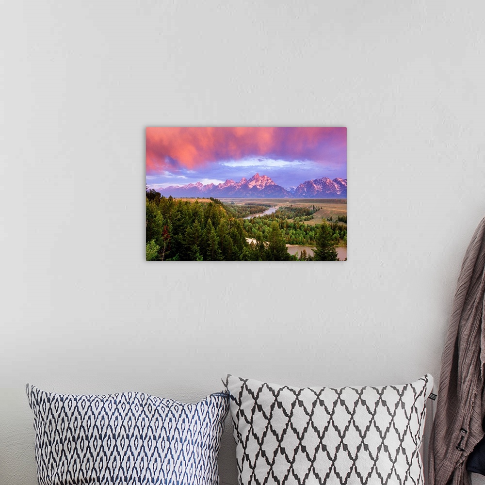 A bohemian room featuring Giant landscape photograph of a vast pine forest in front of the Grand Tetons, beneath a sky of v...