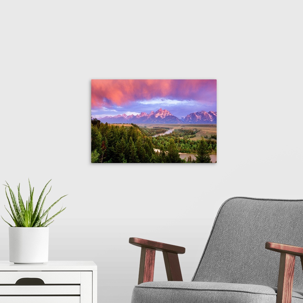 A modern room featuring Giant landscape photograph of a vast pine forest in front of the Grand Tetons, beneath a sky of v...