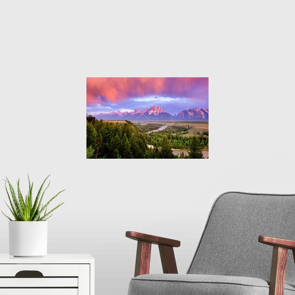 A modern room featuring Giant landscape photograph of a vast pine forest in front of the Grand Tetons, beneath a sky of v...