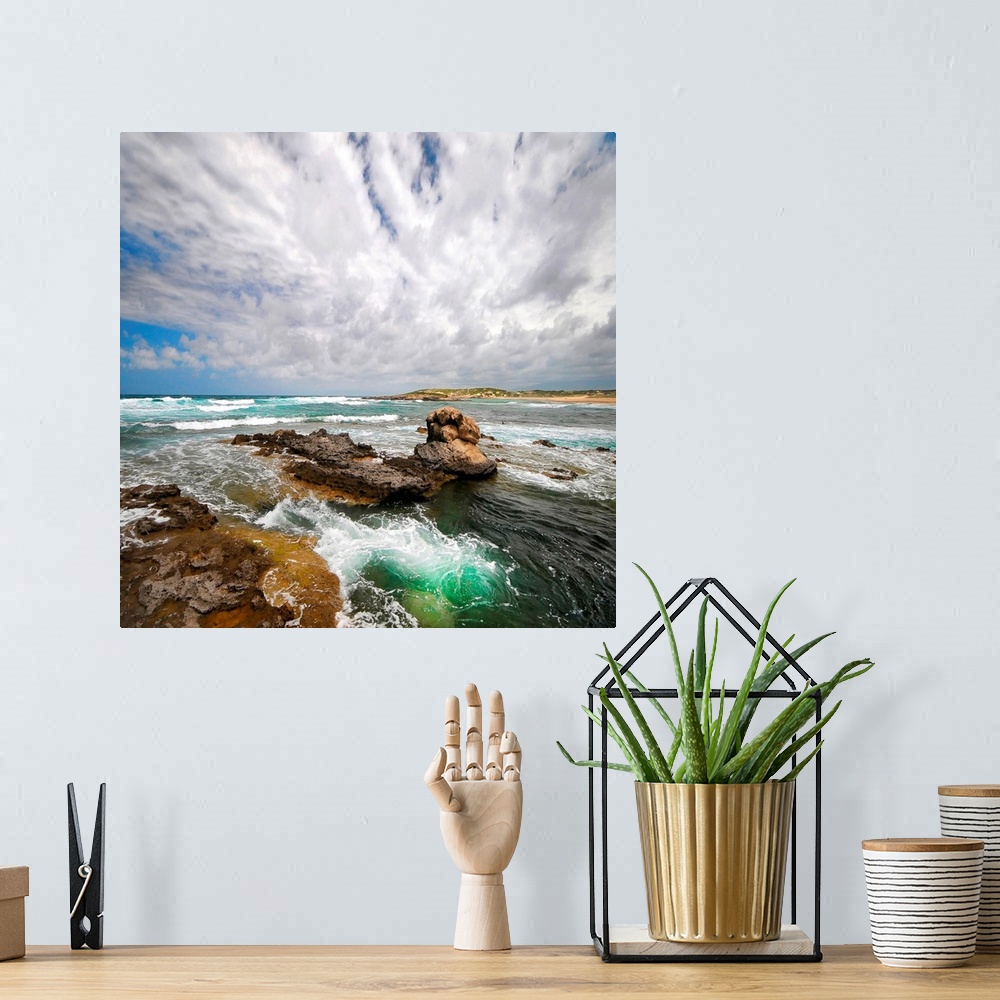 A bohemian room featuring Photograph of rocky surf on a very cloudy day. A small hilly beach is in the distance.