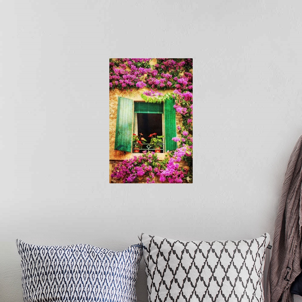 A bohemian room featuring Green shutters on a window surrounded by vibrant pink flowers growing on the wall.