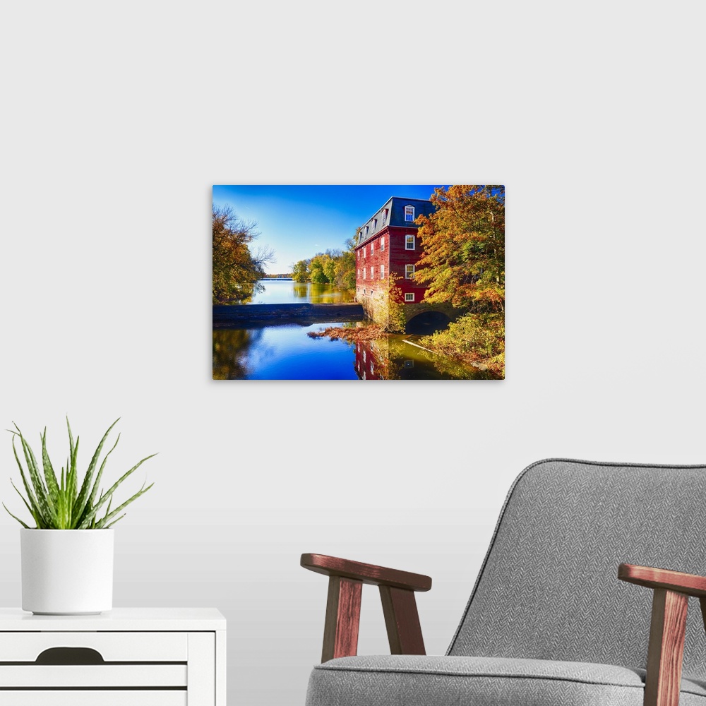 A modern room featuring Red grist mill at the edge of the water at Lake Carnegie, New Jersey, in the fall.