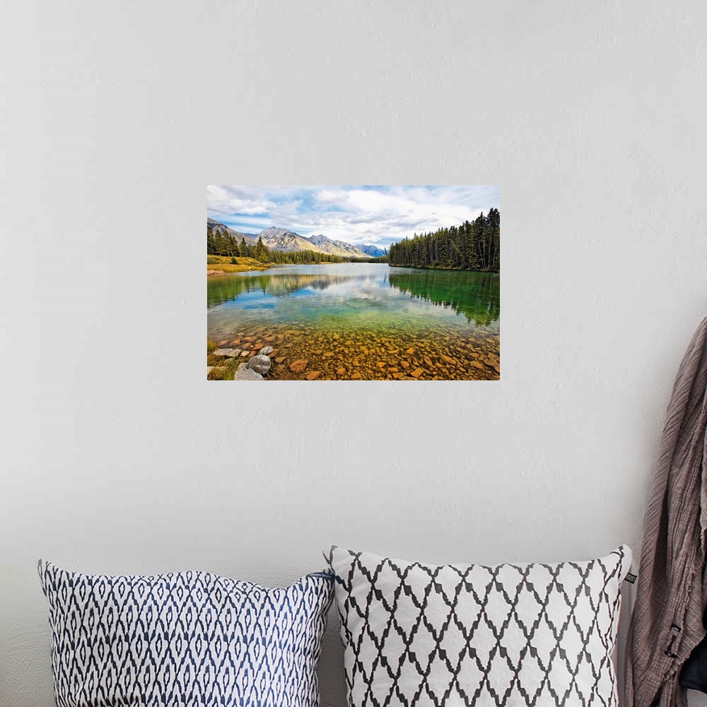 A bohemian room featuring Giant photograph taken from the rocky shores of a lake that is surrounded by dense forests and sn...