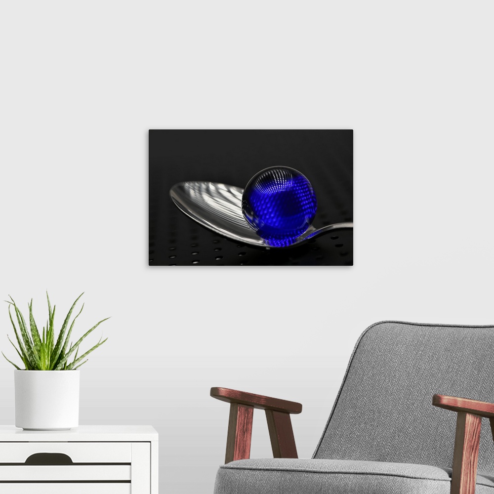 A modern room featuring A blue glass marble on a silver spoon.