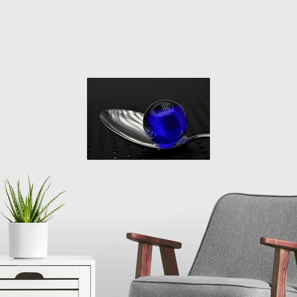 A modern room featuring A blue glass marble on a silver spoon.