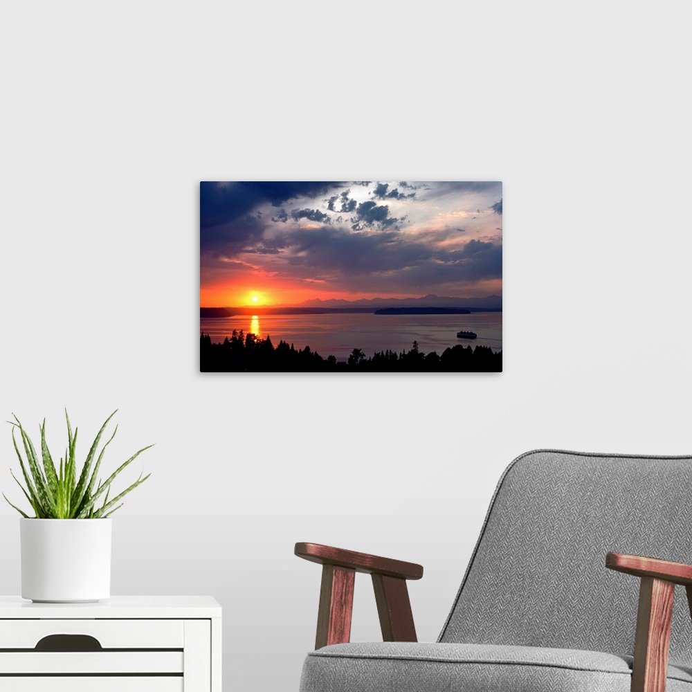 A modern room featuring Photograph looking out over a body of water as the sun sets behind a distant mountain range creat...