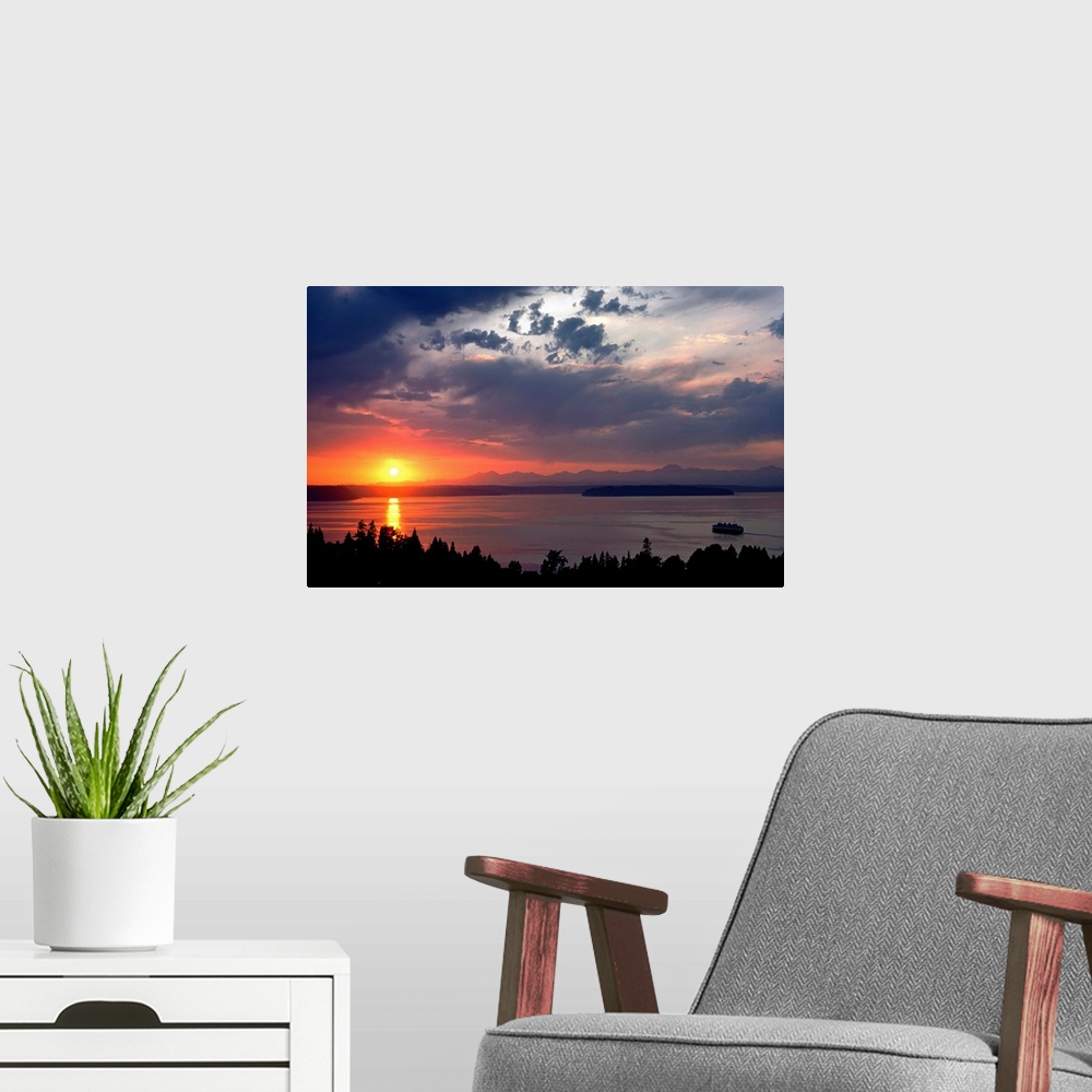 A modern room featuring Photograph looking out over a body of water as the sun sets behind a distant mountain range creat...