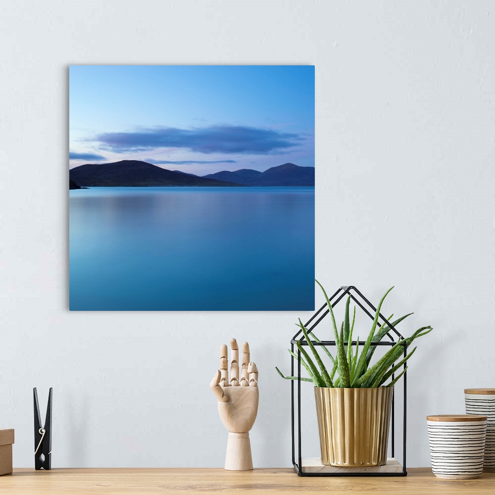 A bohemian room featuring A cool blue minimal zen-like seascape of flat calm water with silhouetted mountains.