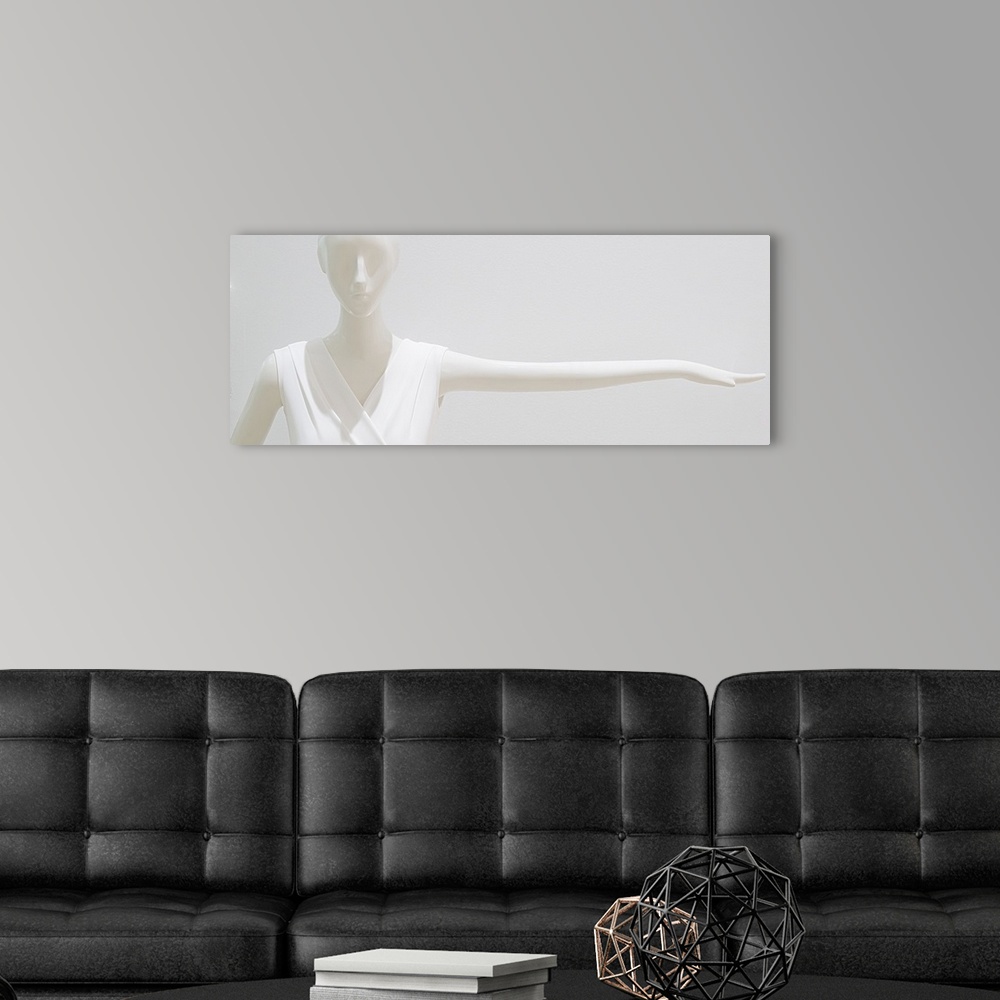 A modern room featuring White mannequin wearing a white outfit blending into a white background.