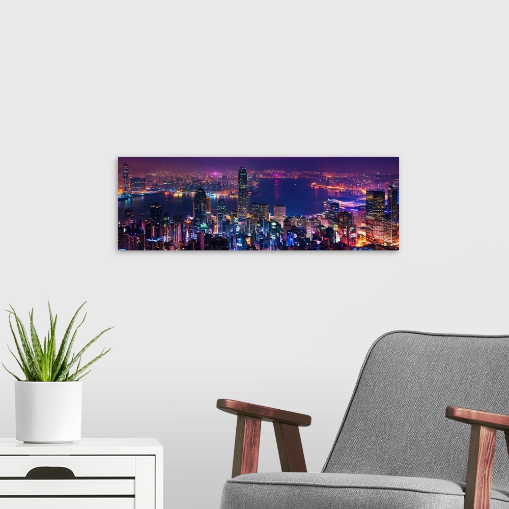 A modern room featuring Panoramic image of the vibrant city of Hong Kong, China at night.