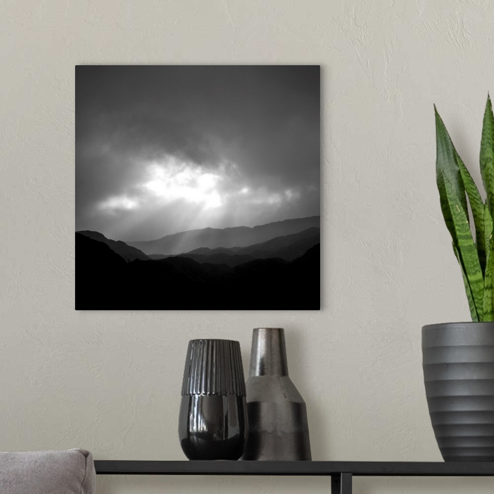 A modern room featuring An uplifting monochromatic image of God's Crepuscular Rays bursting through clouds over silhoutte...