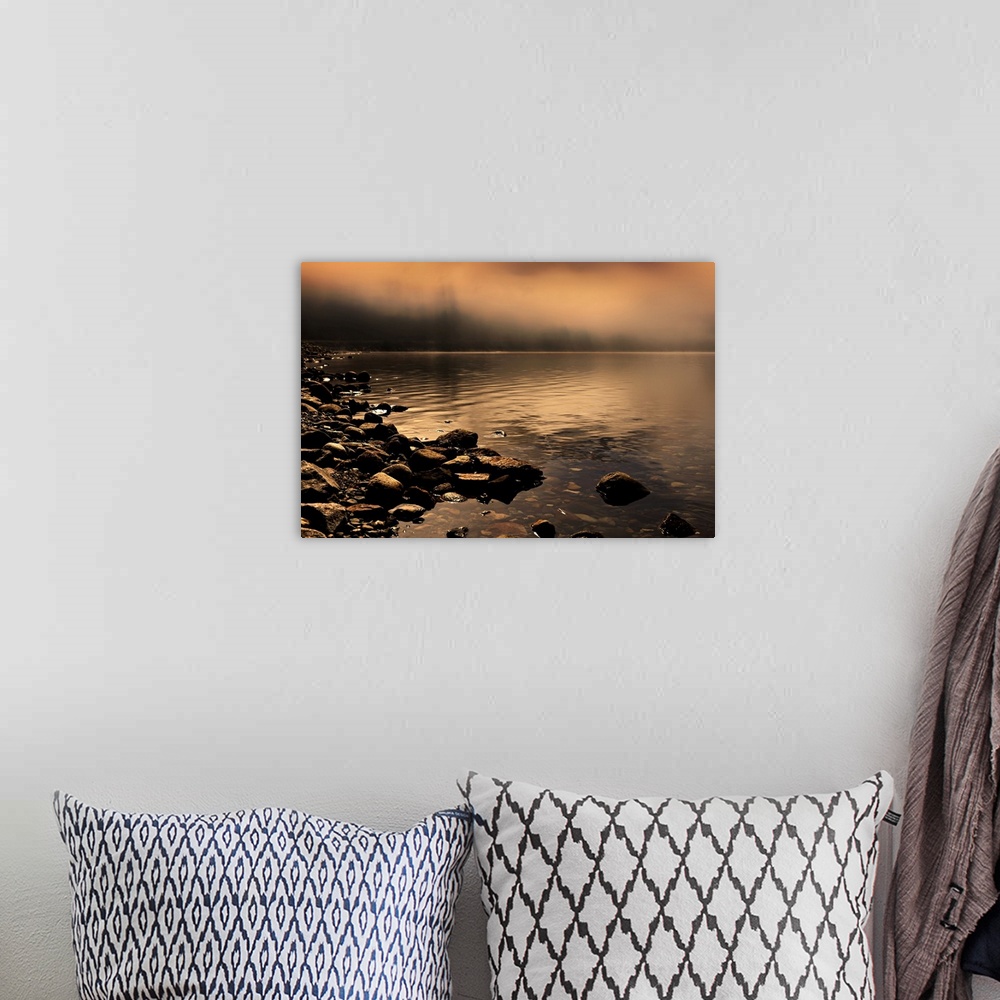 A bohemian room featuring Landscape photograph of a rocky shore with orange fog covering the background.