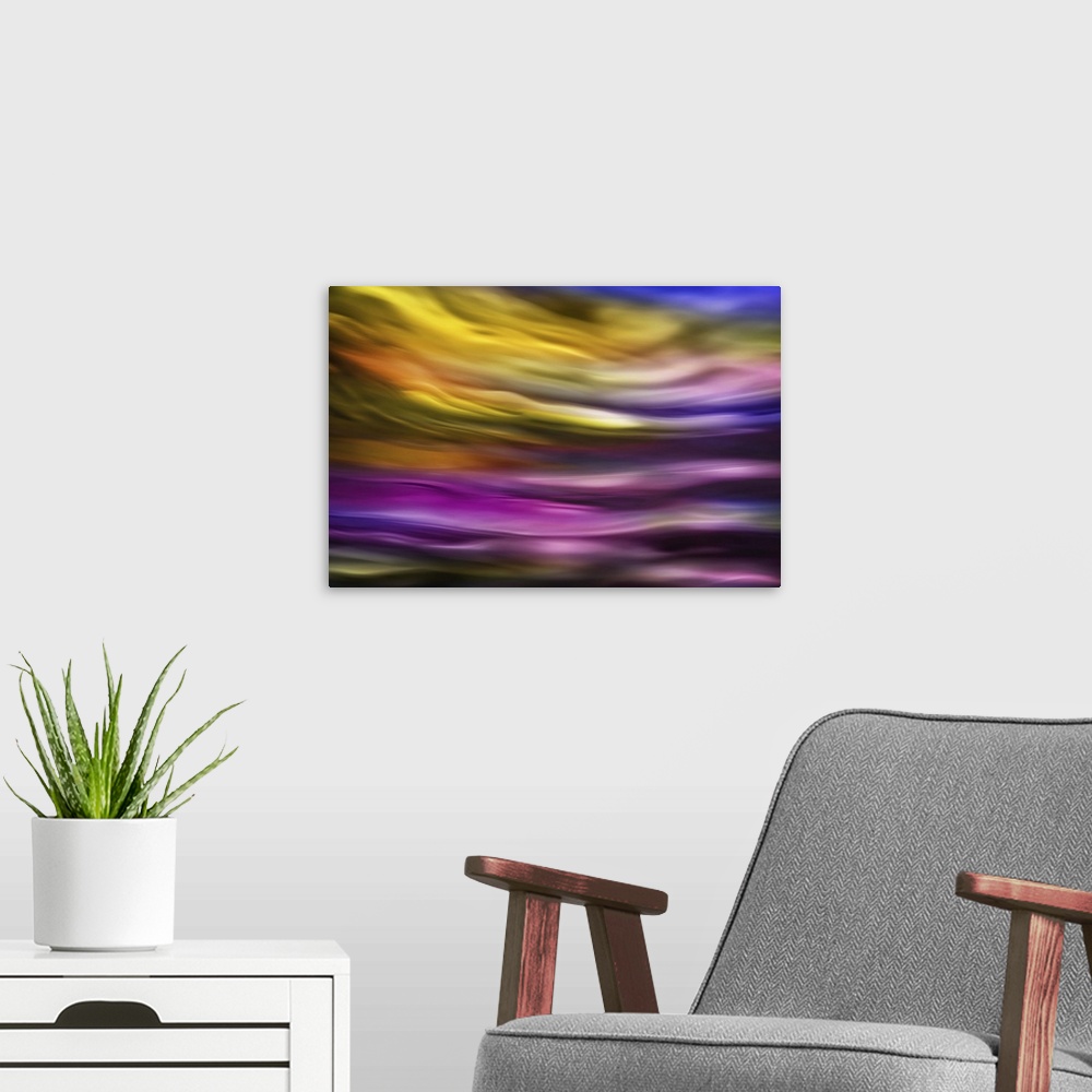 A modern room featuring Abstract photograph of blurred and blended colors and flowing lines in shades of purple and yellow.
