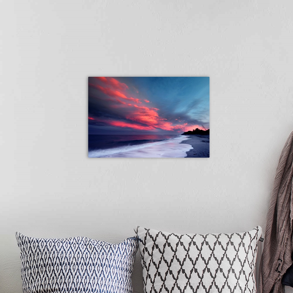 A bohemian room featuring Sunset over the Atlantic ocean with brilliant red clouds over white capped waves