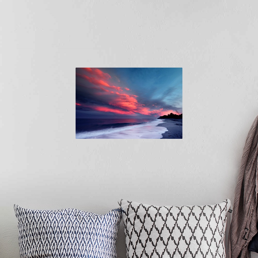 A bohemian room featuring Sunset over the Atlantic ocean with brilliant red clouds over white capped waves