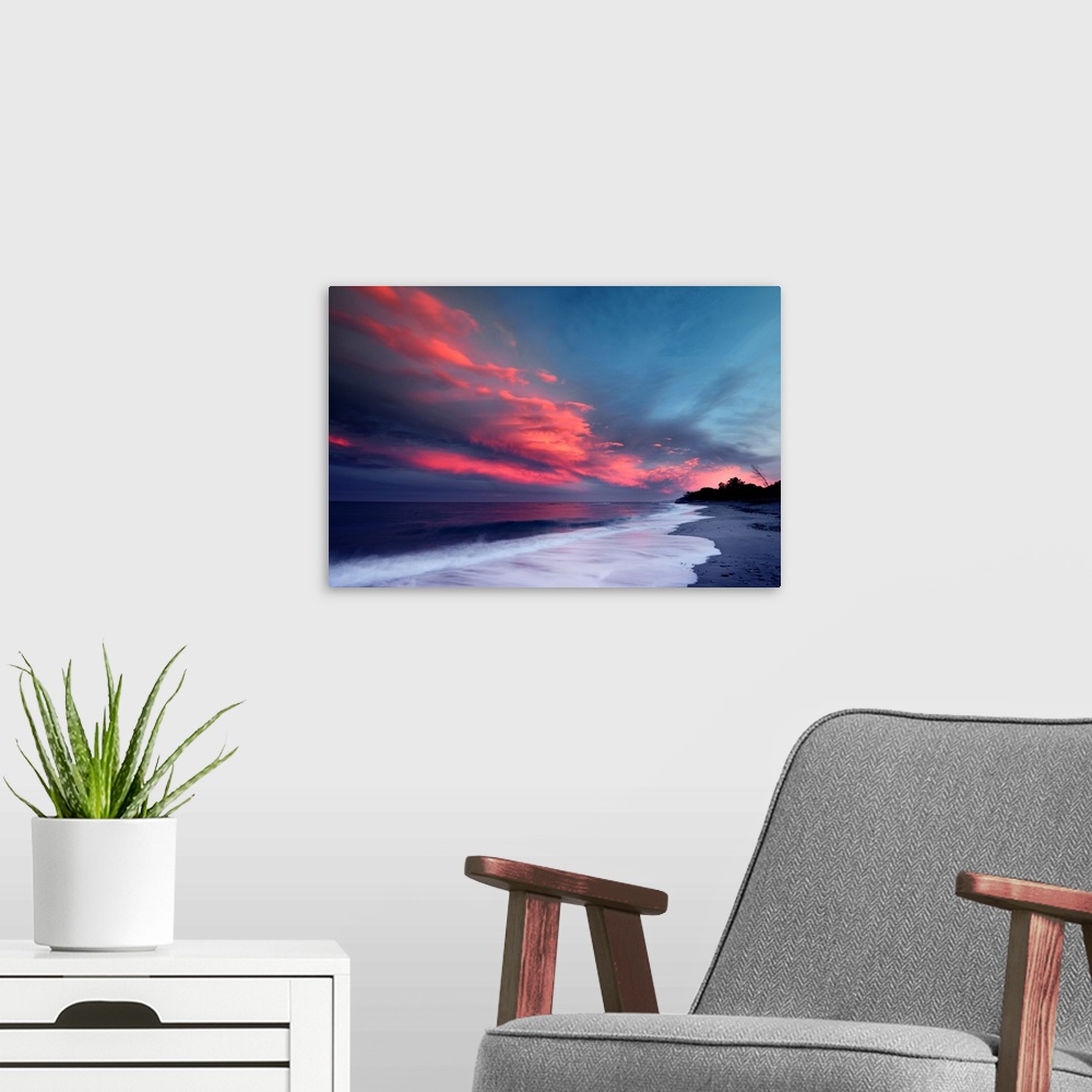 A modern room featuring Sunset over the Atlantic ocean with brilliant red clouds over white capped waves