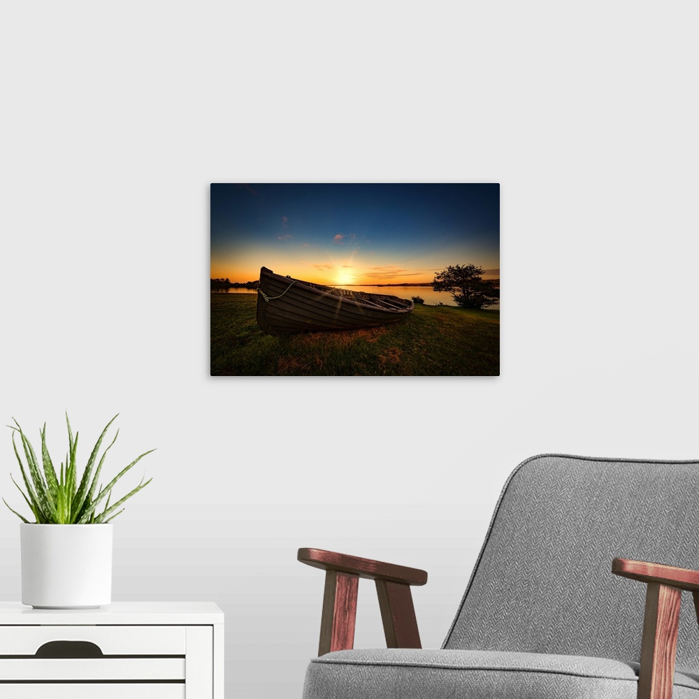 A modern room featuring A rowboat by the sea at sunset