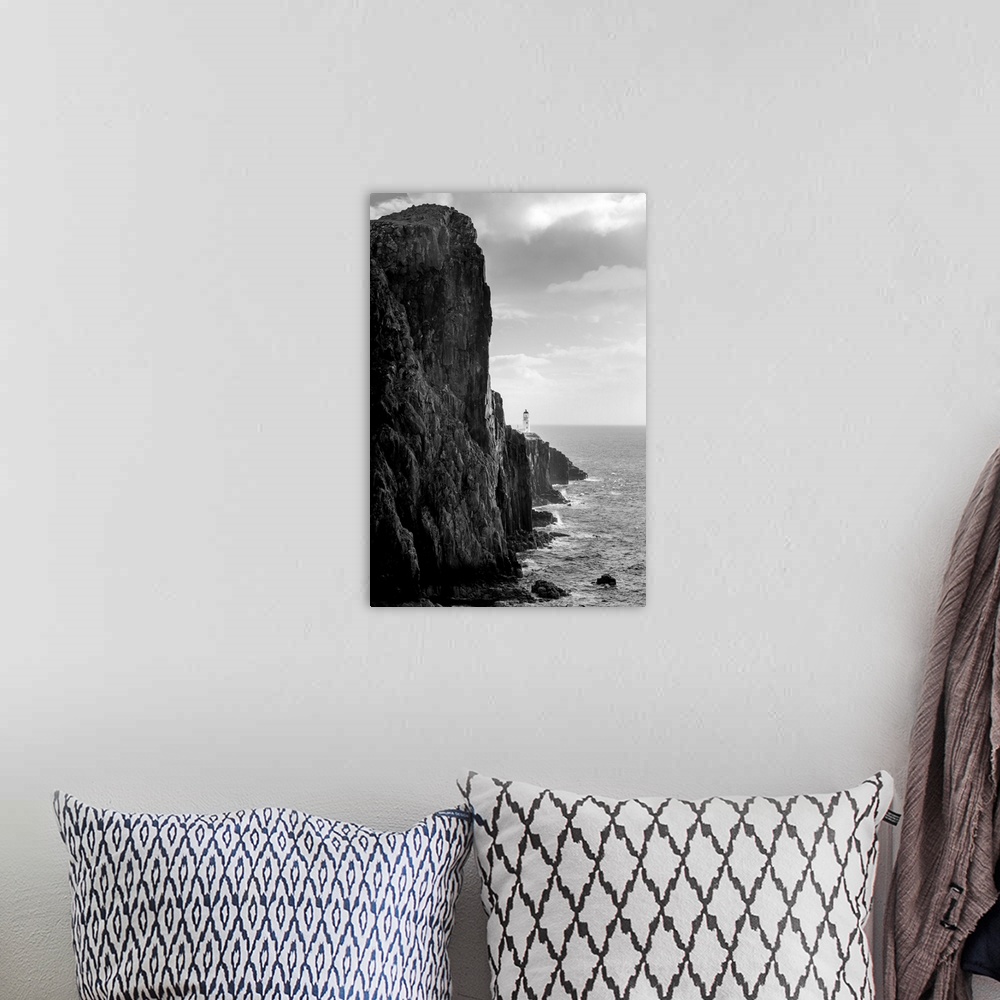 A bohemian room featuring Fine art photo of a steep ocean cliff with rocks below, in black and white.