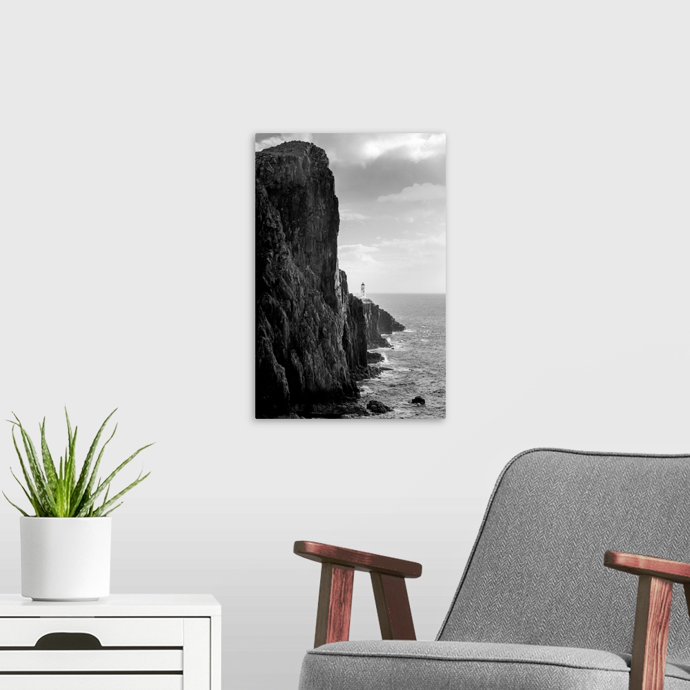A modern room featuring Fine art photo of a steep ocean cliff with rocks below, in black and white.