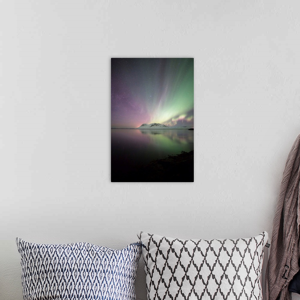 A bohemian room featuring Green and purple northern lights over the ocean and mountains in Iceland at night.