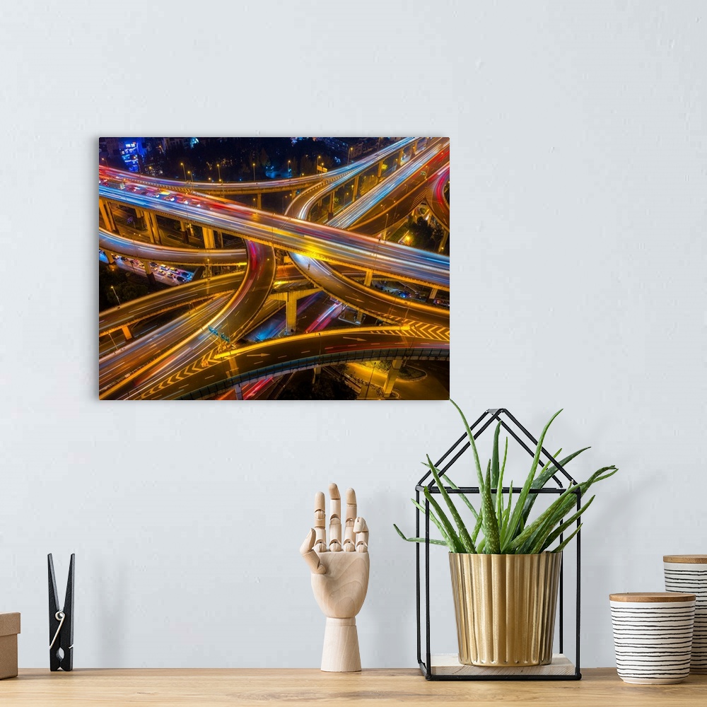 A bohemian room featuring Ariel view of highway bridges intertwining as cars drive by at night.