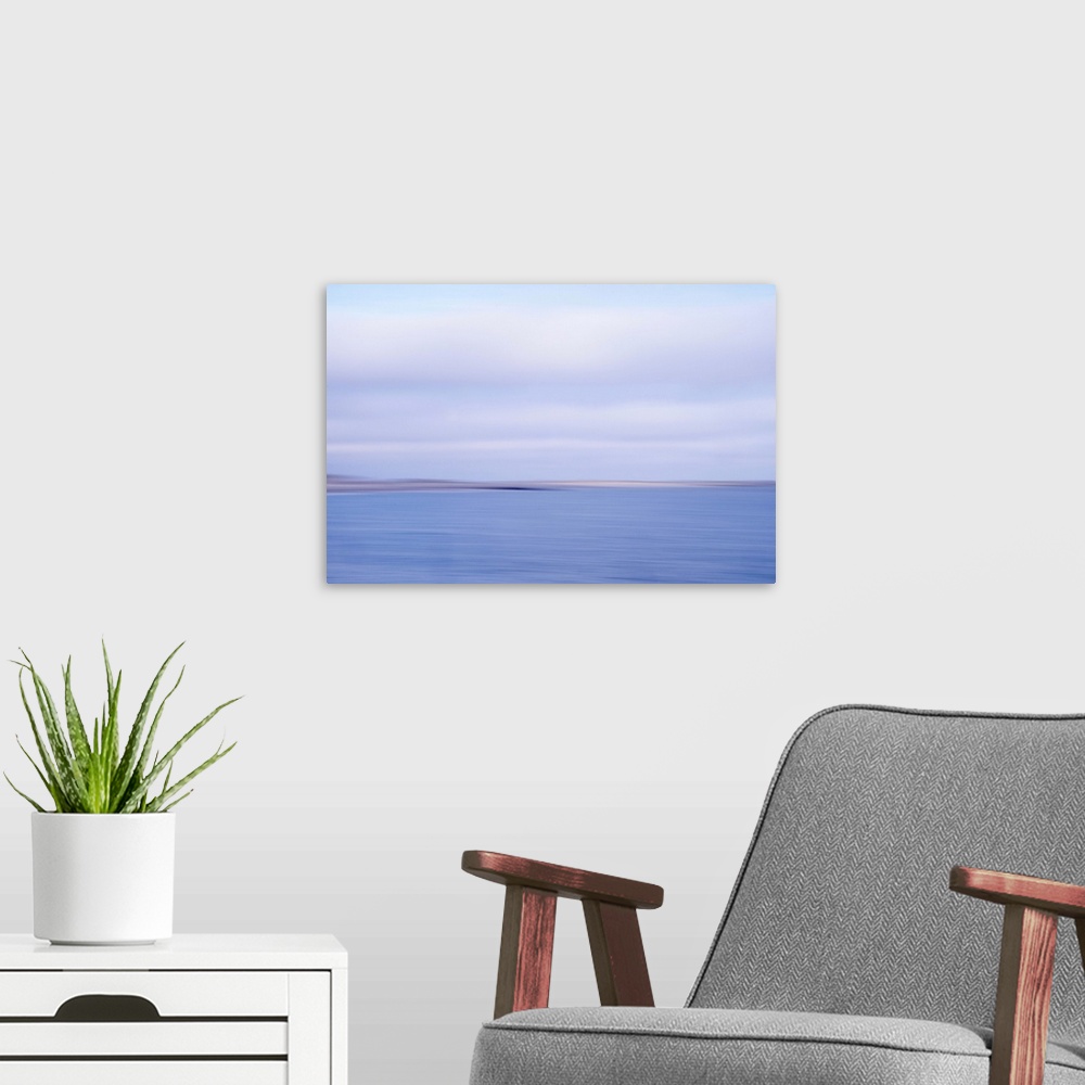 A modern room featuring Artistically blurred photo. View on the beach and dunes of the North Sea; land and sea in an inev...