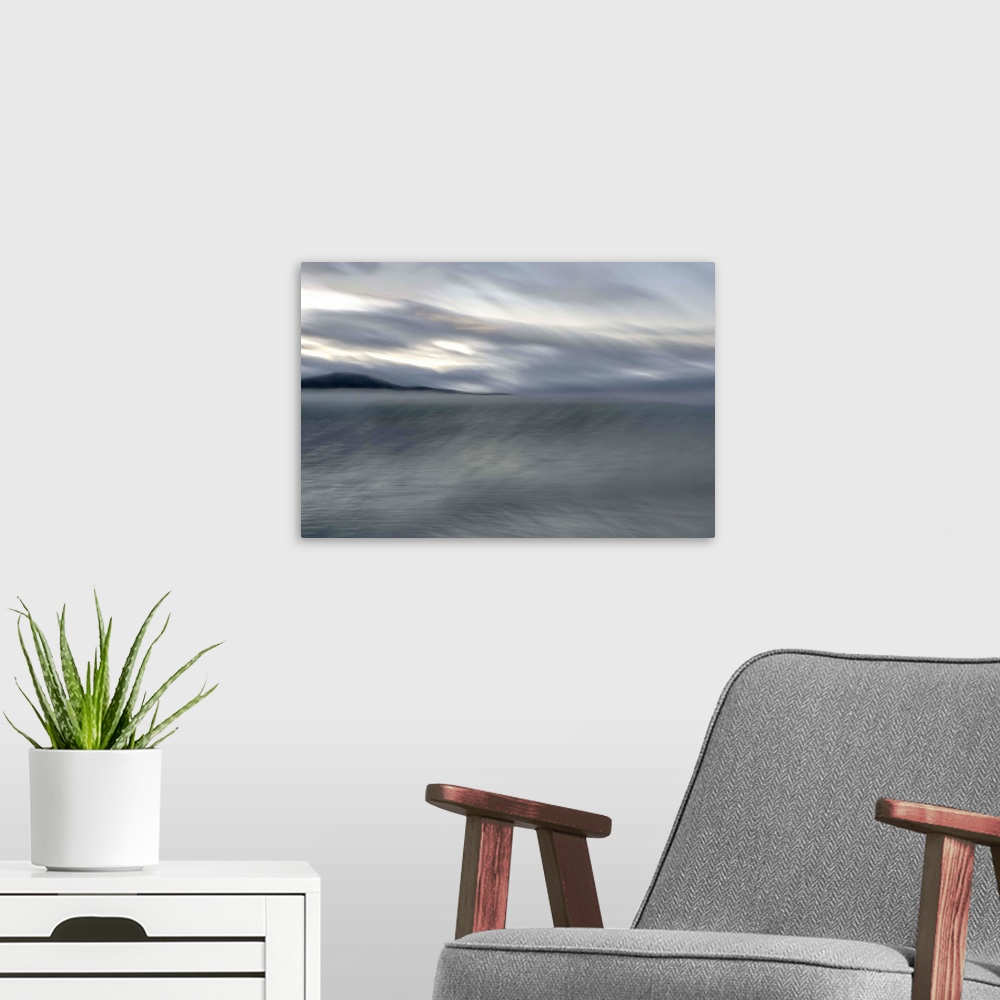 A modern room featuring Blurred image of a lake with stormy skies above and a mountain in the distance.