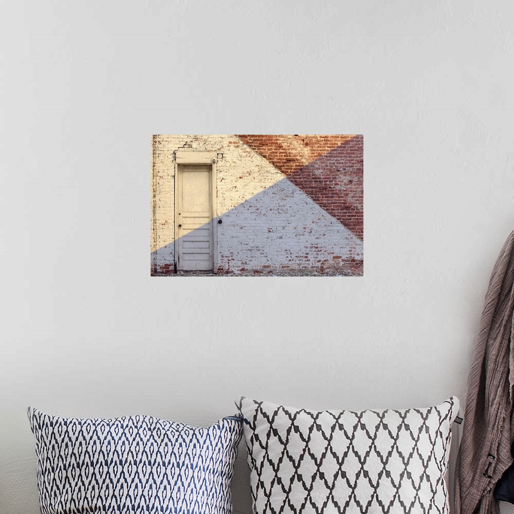 A bohemian room featuring Photograph of an aged brick wall with a white door, angled paint lines, and an angled shadow on h...