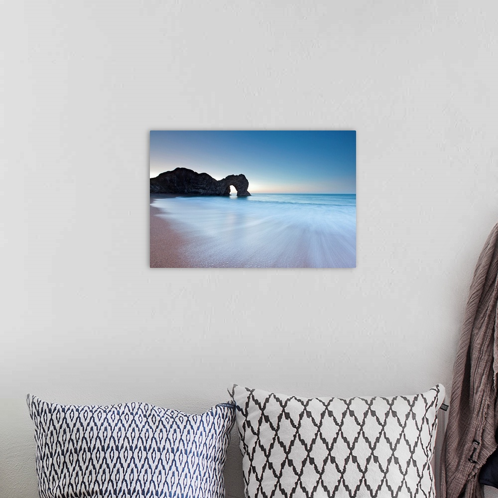 A bohemian room featuring Durdle Door rock arch on the Dorset coast at sunrise with a blue sky and swooshing waves in minim...