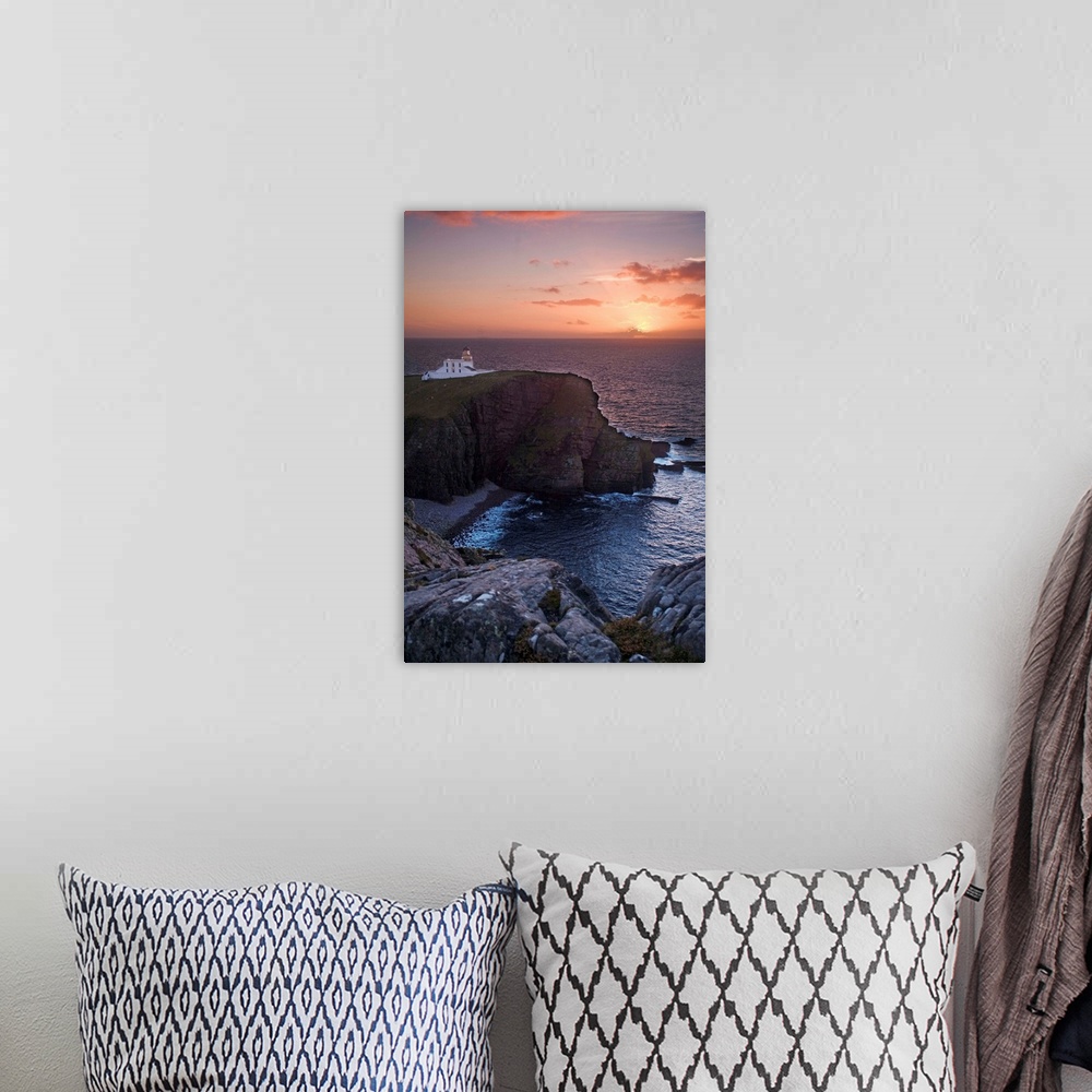 A bohemian room featuring A sunset seascape over Neist Point Lighthouse, Isle of Skye, Scotland with a peach and gold sky.