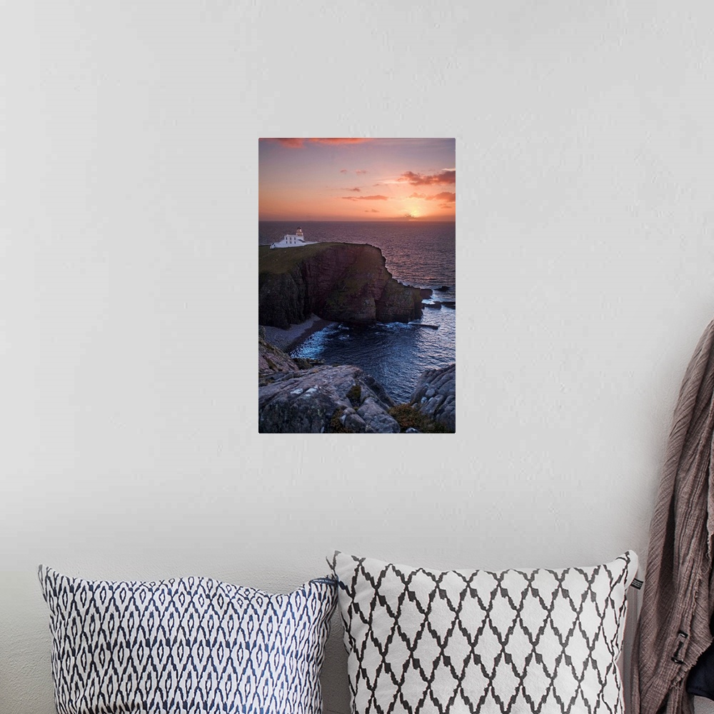 A bohemian room featuring A sunset seascape over Neist Point Lighthouse, Isle of Skye, Scotland with a peach and gold sky.