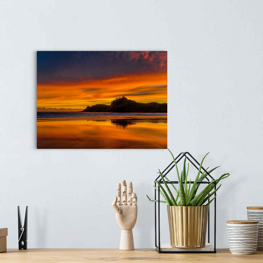 A bohemian room featuring Silhouetted sea stacks off the Oregon coast under a stunning orange sunset.