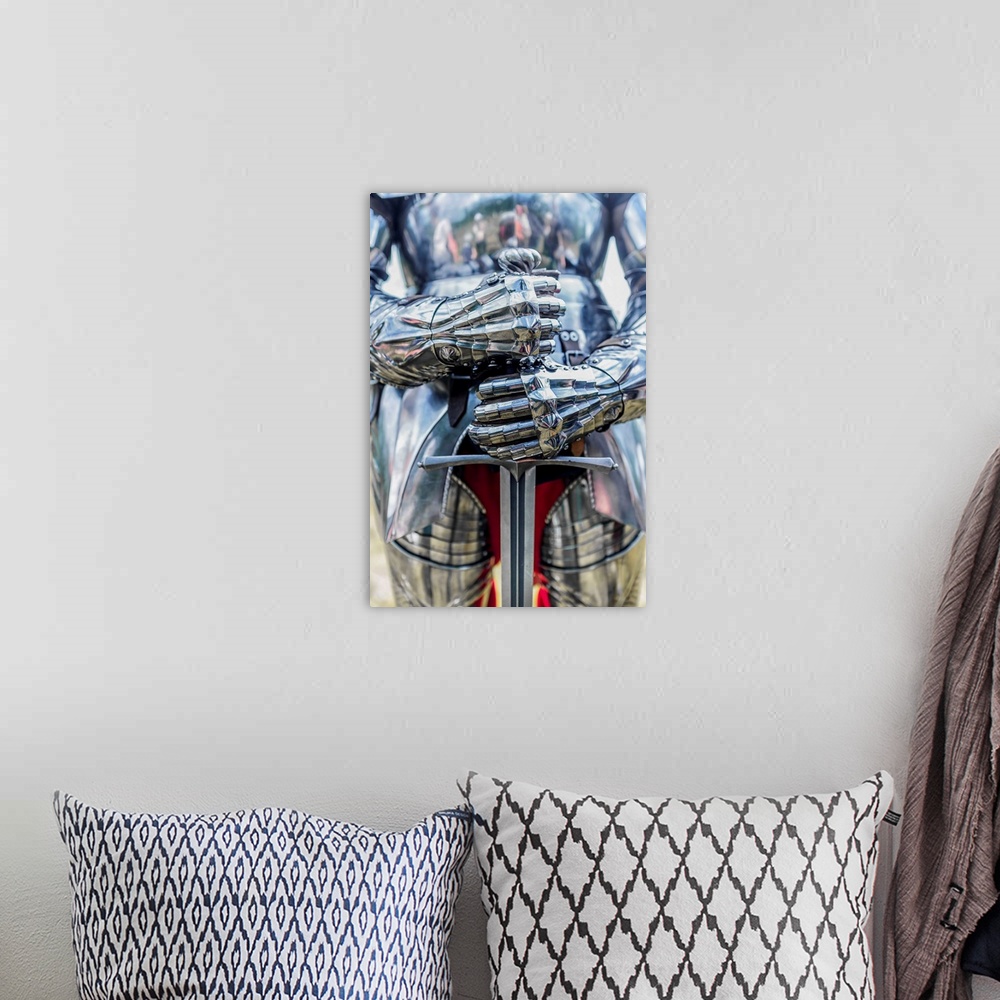 A bohemian room featuring A photograph of a close-up on a suit of armor holding a sword.