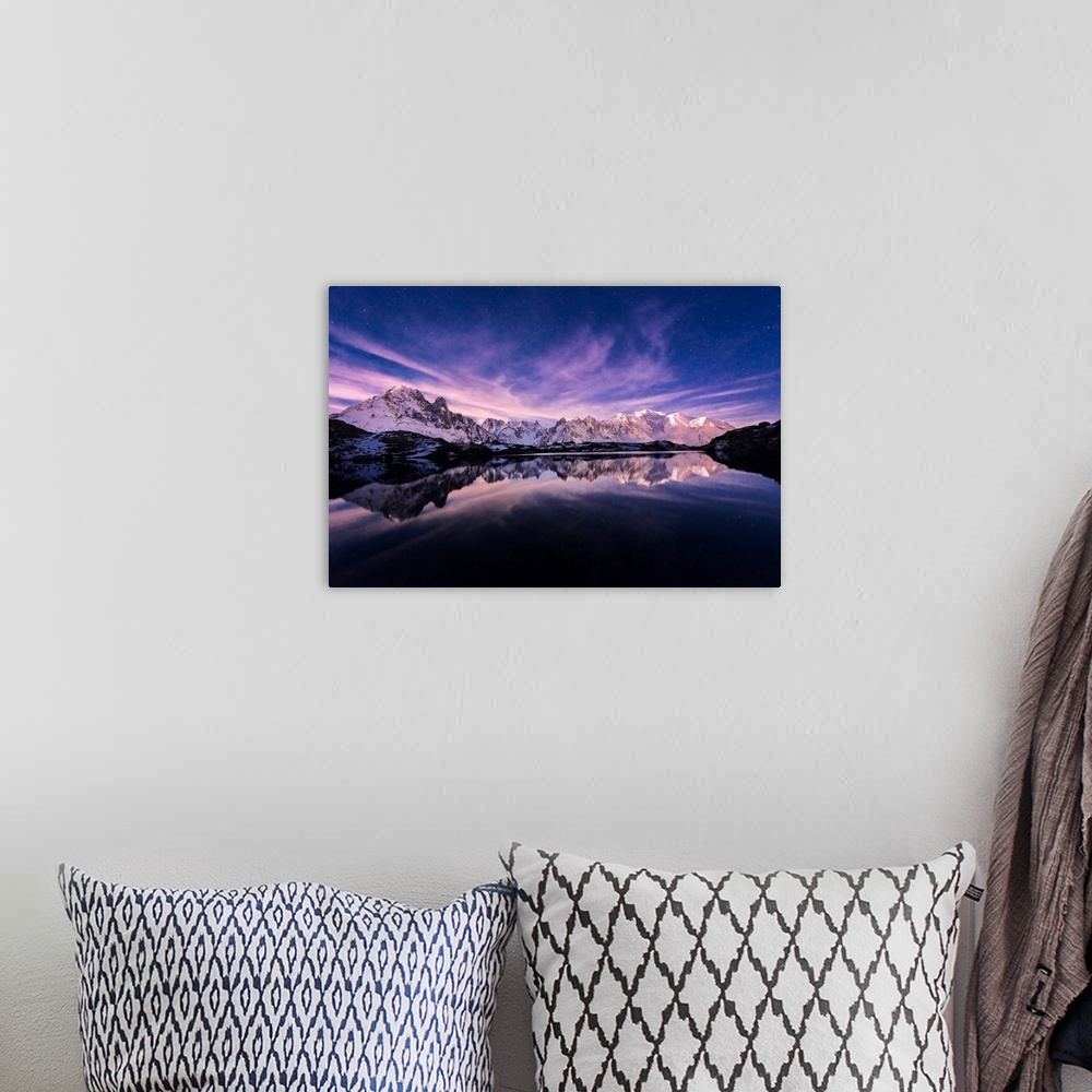 A bohemian room featuring Fine art photograph of a snowy mountain range reflected in the water under a lavender sky in France.