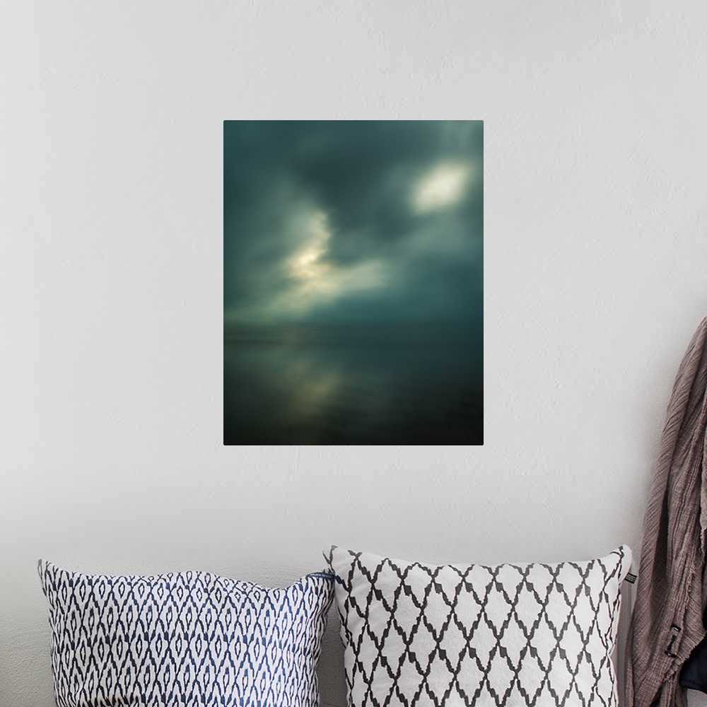 A bohemian room featuring Dream-like photograph of a calm ocean with the sun starting to peak through a cloudy sky.