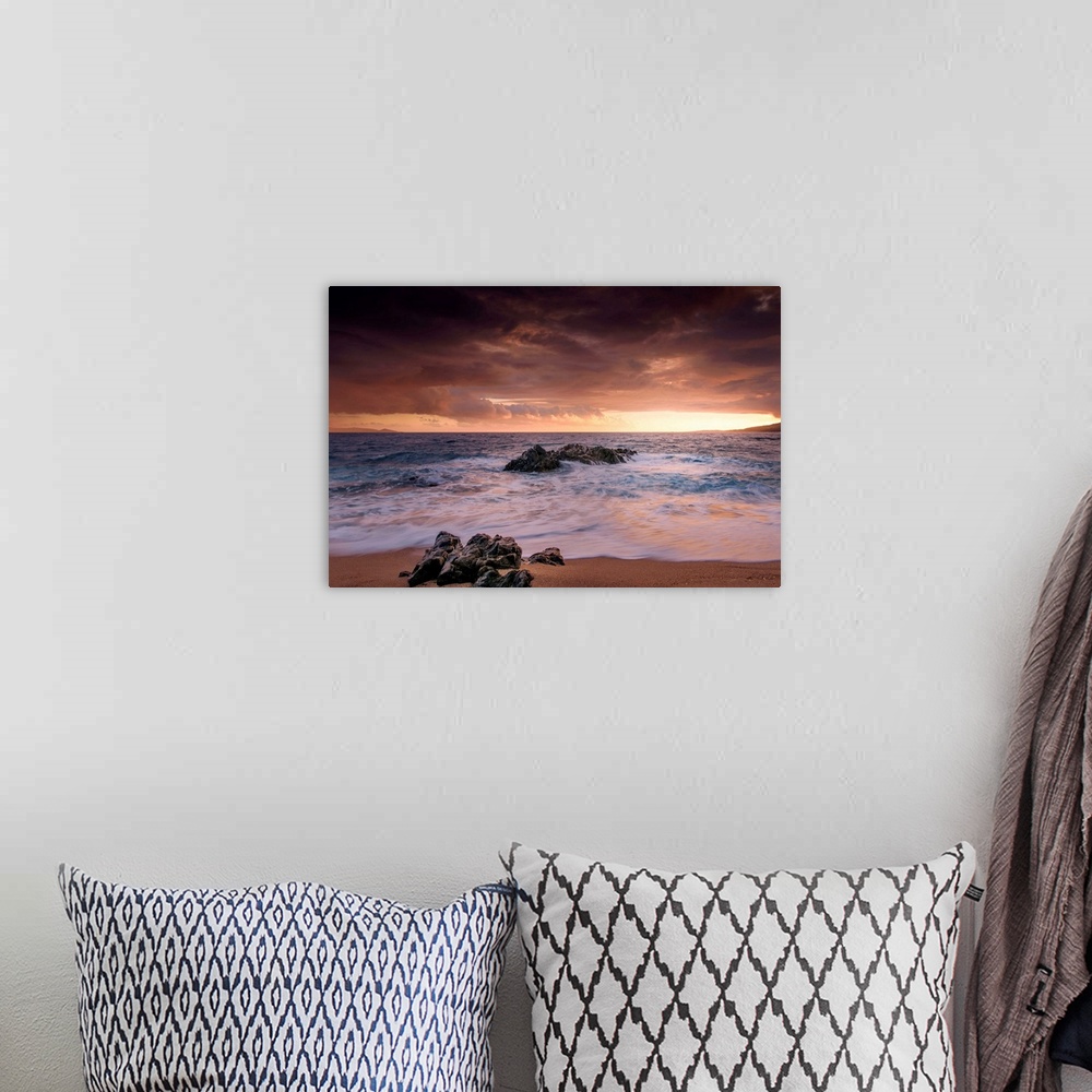 A bohemian room featuring A photograph of a rocky sunset coastal landscape.