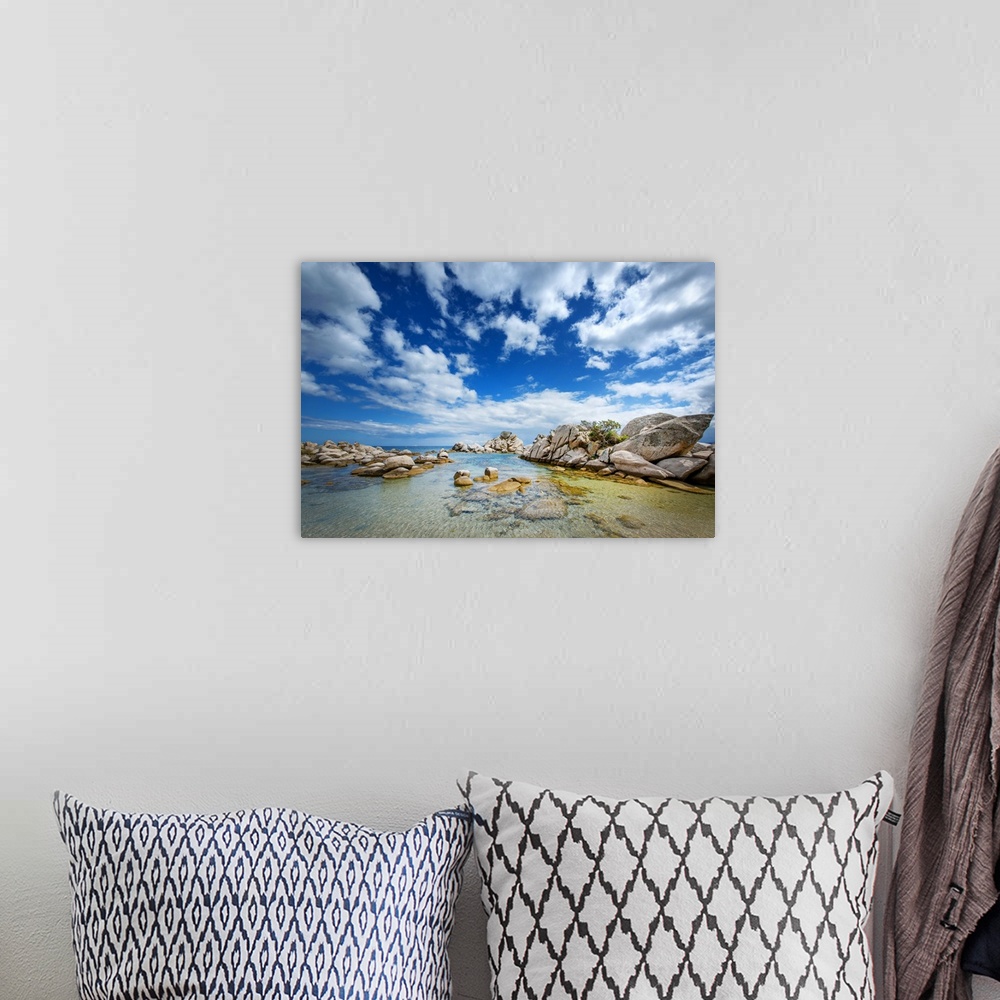 A bohemian room featuring A photograph of a rocky coastline under a sky filled with dramatic clouds.