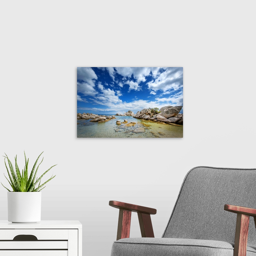 A modern room featuring A photograph of a rocky coastline under a sky filled with dramatic clouds.