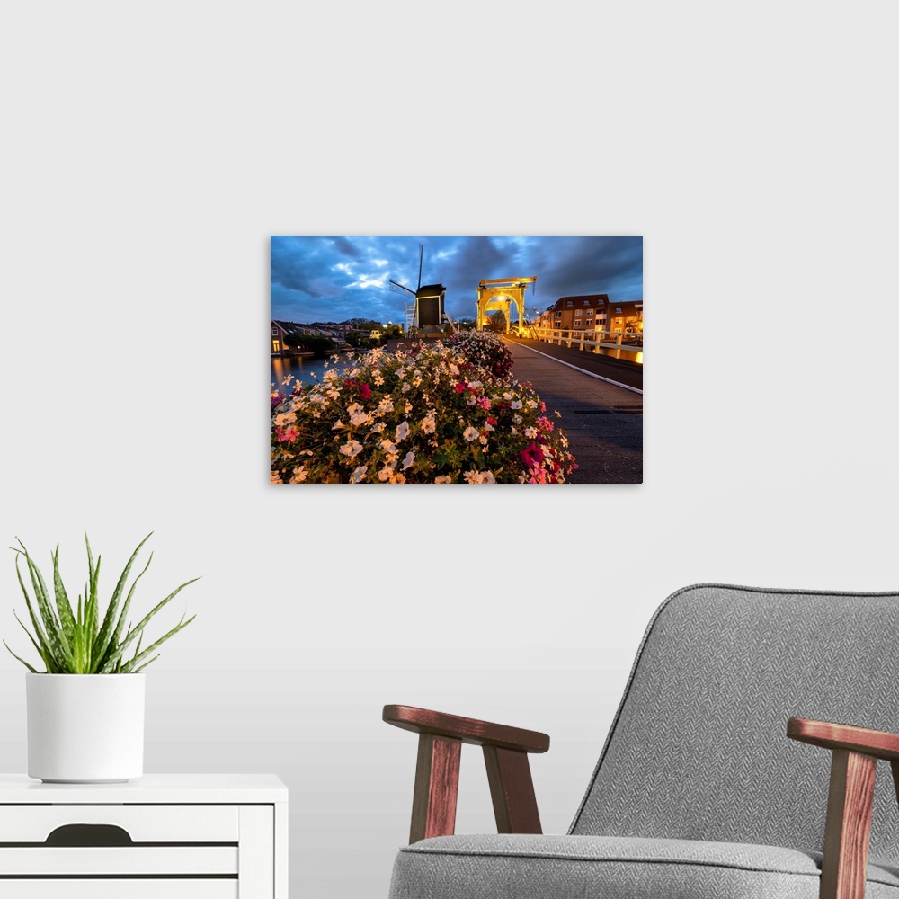 A modern room featuring Drawbridge and windmill at night with blooming flowers, Leiden, South Holland, Netherlands.