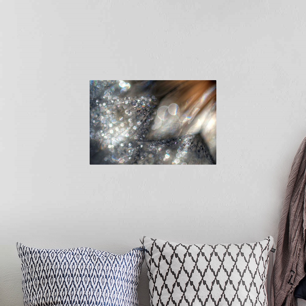 A bohemian room featuring Large abstract canvas print of light and earth toned colors with bright and dark circles of light...