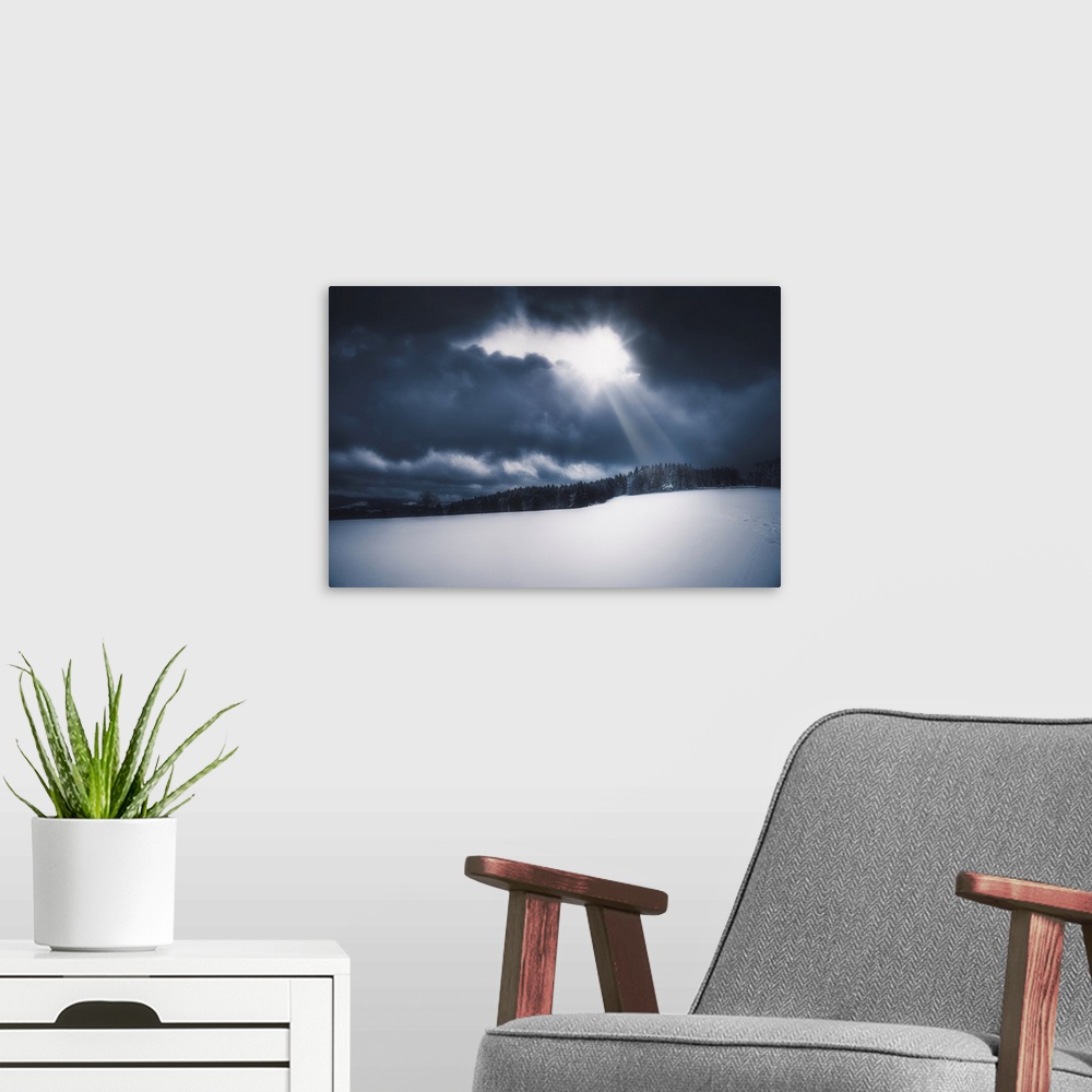 A modern room featuring Snowy landscape lit by the sun piercing a stormy sky