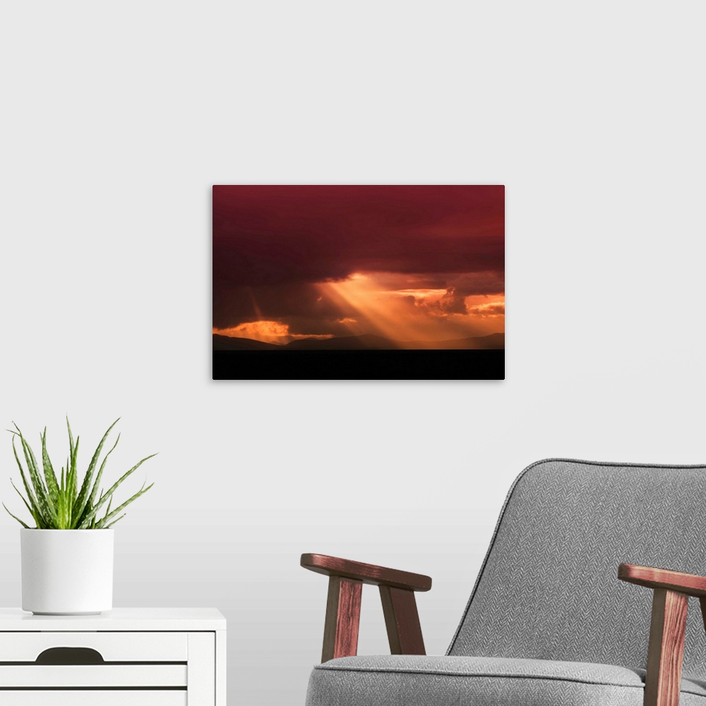 A modern room featuring Fine art photo of a bright beam of light shining through the clouds at sunset.