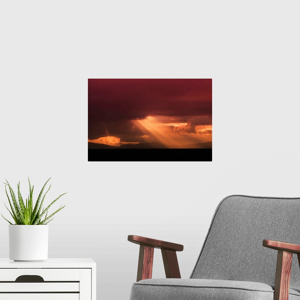 A modern room featuring Fine art photo of a bright beam of light shining through the clouds at sunset.