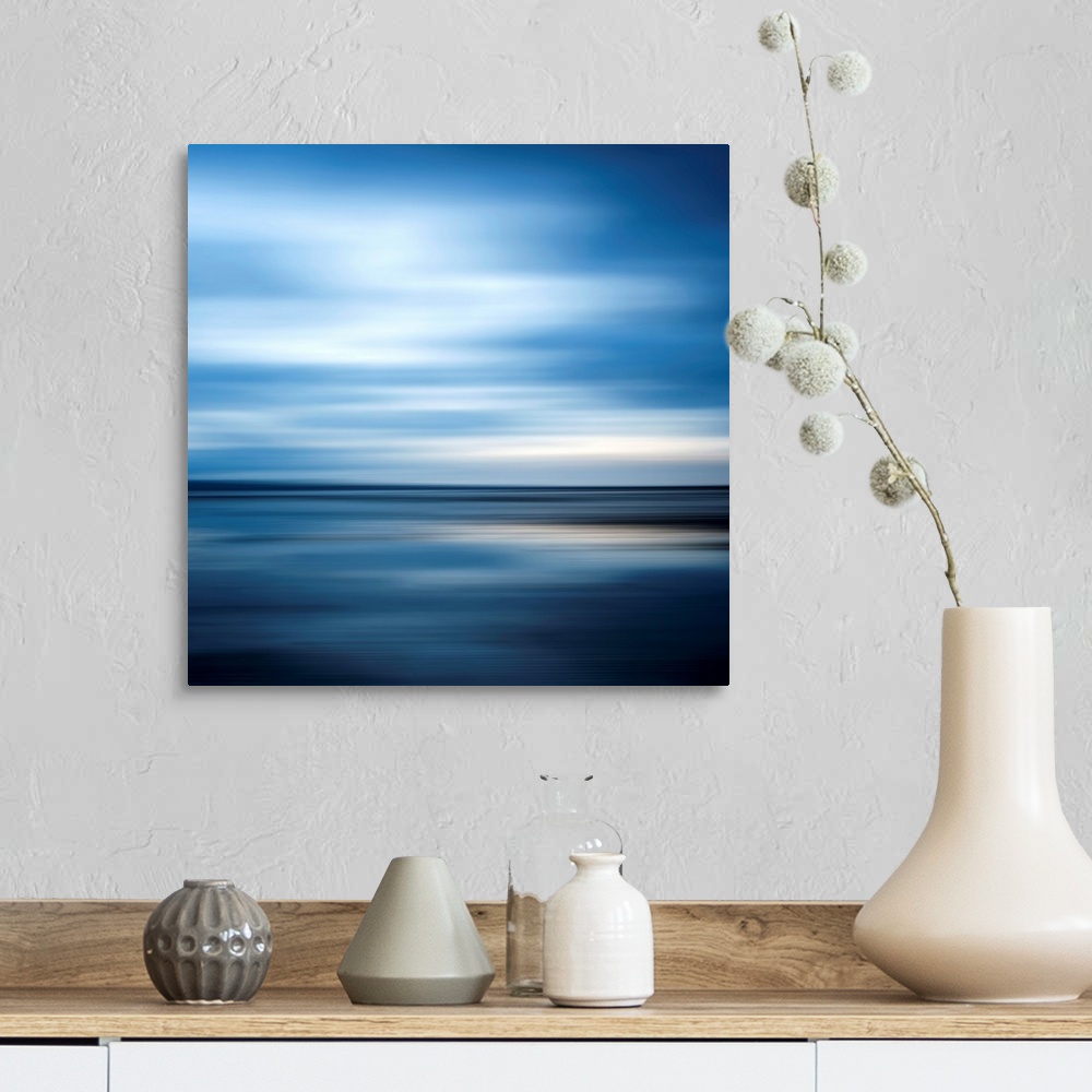 A farmhouse room featuring Huge square abstract art of an ocean against a clear sky that includes a lot of horizontal lines.